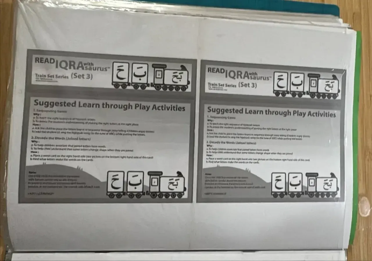 Two black-and-white Read Iqra with Saurus Train Set (Set 3) cards, each with suggested learn-through-play activities and a train carrying hijaiyah letters