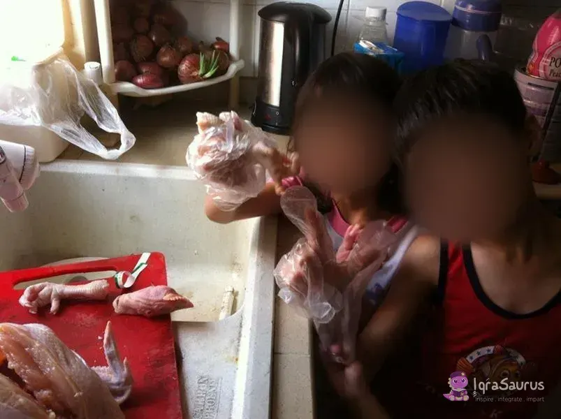 Two children in plastic gloves cleaning chicken at the kitchen sink