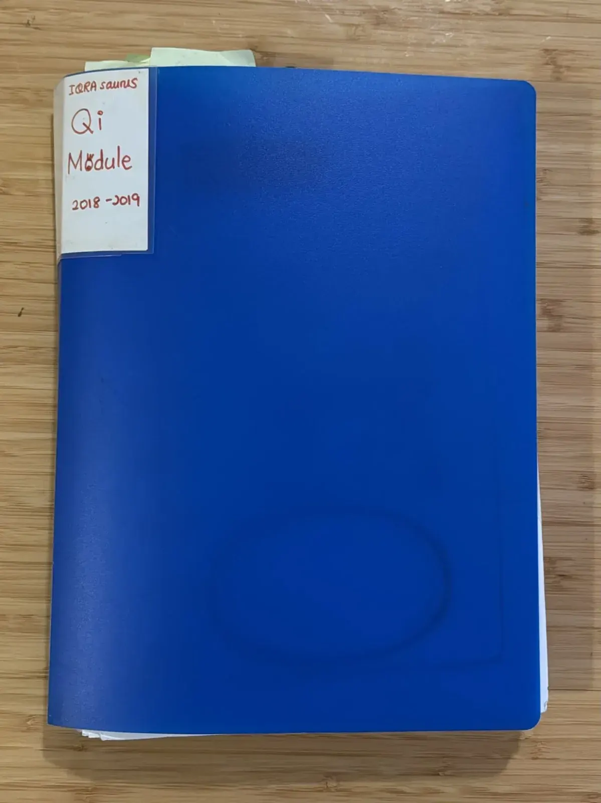 A blue document folder with a handwritten spine label: IQRAsaurus, Qi Module, 2018-2019