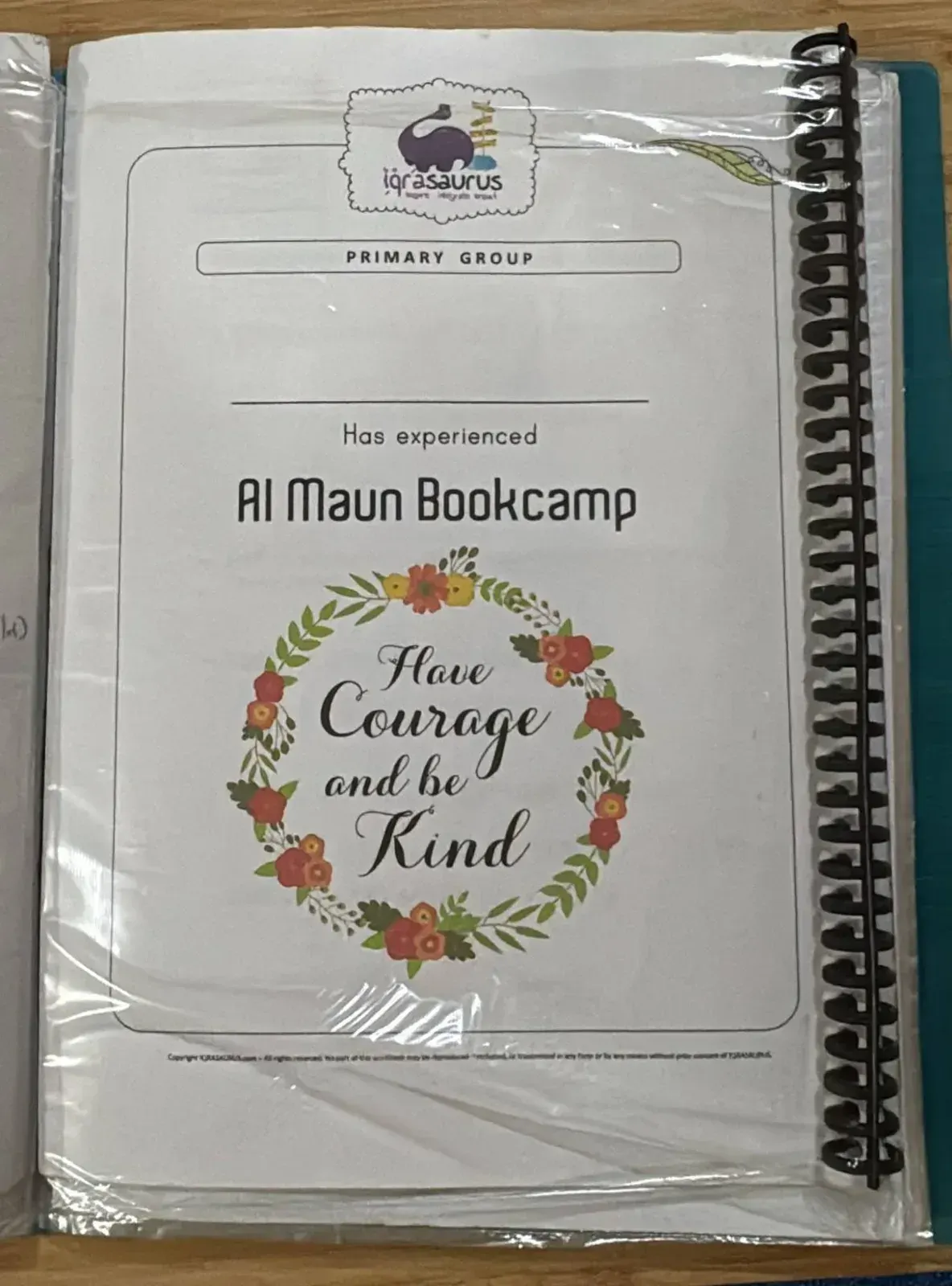 The Primary Group cover of the Al Maun Bookcamp workbook, spiral-bound in a plastic sleeve
