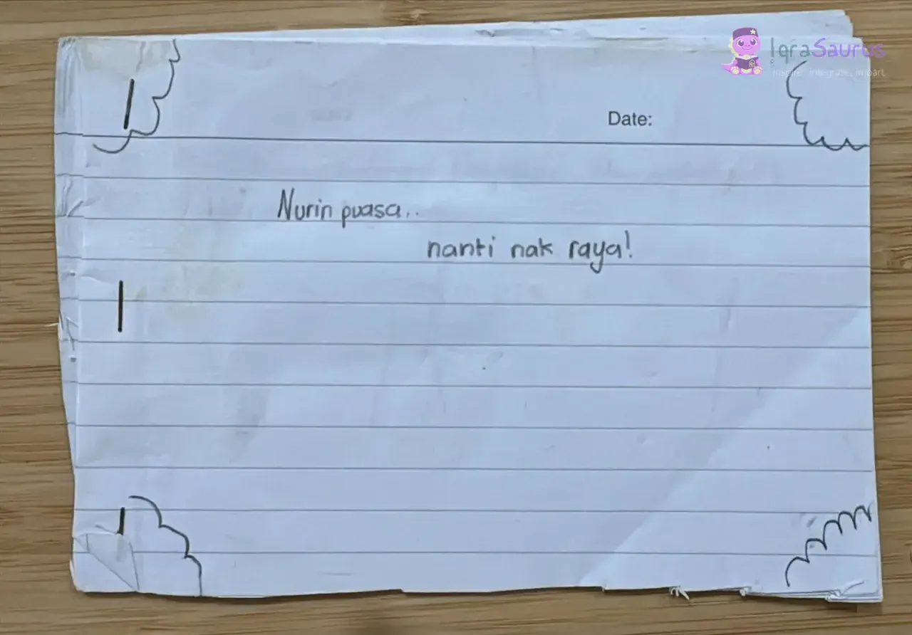 Home-made mini book cover reading Nurin puasa.. nanti nak raya!, with clouds drawn in the corners